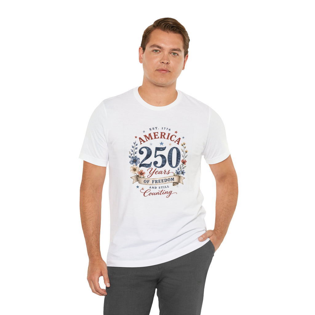 White t-shirt with "America 250 Years Of Freedom Still Counting" graphic.