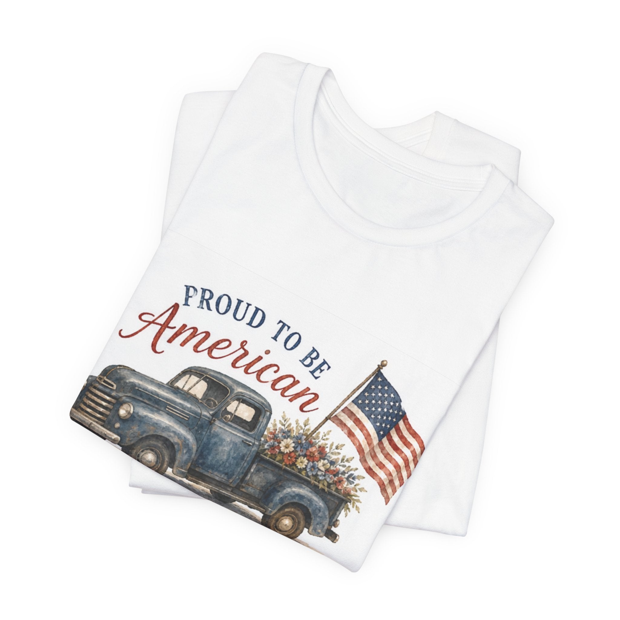 White t-shirt with vintage blue truck, flowers, and "Proud to be American" text.